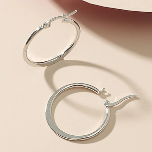 Minimalist silver hoop earrings with polished mirror finish and secure clasp closure