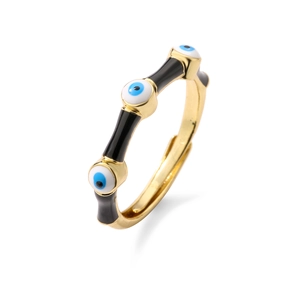 Detail of golden bamboo adjustable ring with black enamel and blue evil eye charms