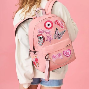 Pink nylon backpack featuring embroidered patches with butterfly heart and slogan