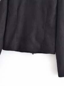 Detailed macro view of the black faux suede fabric texture and hem stitching quality