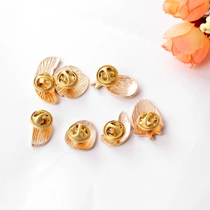 7-piece set of gold alloy fruit-shaped brooch bases with butterfly clasps on white surface