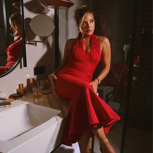 Nahaufnahme vom roten Neckholder-Kleid mit Rüschensaum an Model im Badezimmer
