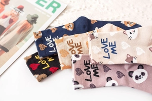 Detail of five colored cotton socks featuring animal patterns and love me embroidery