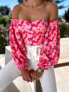 Detail of off-shoulder pink floral top with long lantern sleeves on a model outdoors