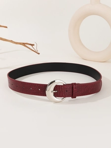 Detail of red crocodile pattern leather belt with a crescent-shaped silver buckle