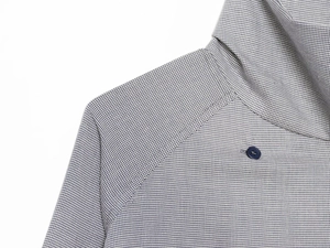 Detailed macro view showing blue plaid fabric texture and dark round button on the shirt