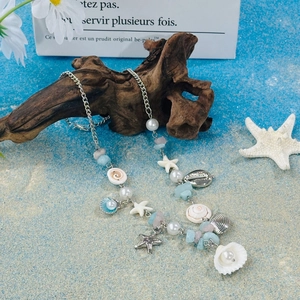 Detail view of seaside shell and starfish beaded necklace with pearls on driftwood