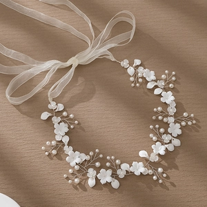 Detail showing white ceramic flowers and pearls woven on a silver bridal headband
