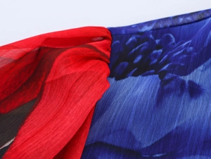 Detail of red pleated fabric stitched with blue floral chiffon on short sleeve blouse