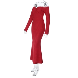 Detail of red off-shoulder maxi dress featuring intricate lace trim and textured fabric