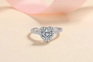 Detailed view of a silver heart-shaped diamond ring with an elegant pink ribbon