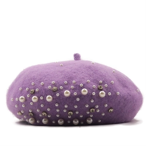 Detail shot of purple wool knit beret featuring scattered white pearls and sparkling rhinestones
