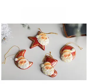 Dettagli di ornamenti natalizi in ceramica rossa festiva con bordi dorati e cordini