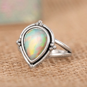 Détail macro d'une bague vintage en argent avec opale poire sur tissu rustique