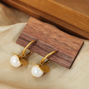 French retro gold earrings with white pearl and irregular leaf drop on silk background