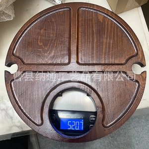 Macro shot of circular wooden picnic snack tray with three compartments and wine glass slots