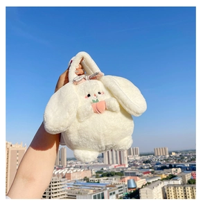 Detailed view of a plush white bunny handbag with a pink peach and blue sky background