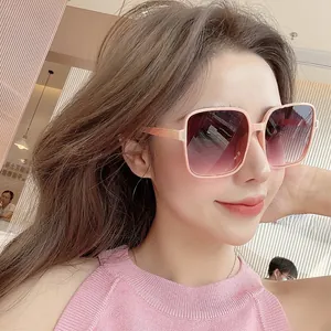 Fashionable oversized square sunglasses with pink gradient lenses worn by a model