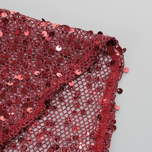 Détail de paillettes bordeaux et tissu en maille fine sur une robe de soirée sexy