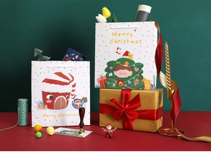 Close-up of Christmas gift paper bag and gold box with festive red ribbon decoration