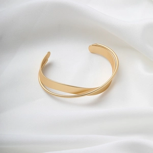 Bracciale rigido incrociato in oro opaco minimalista con design geometrico a doppio strato