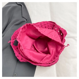 Dettaglio borsa a tracolla intrecciata con uncinetto rosso rosa e sacchetto interno con coulisse