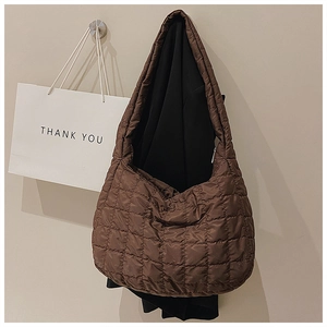 Close-up of brown quilted tote bag with diamond pattern and soft down-like texture