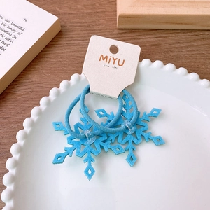 Close-up of light blue felt snowflake hair clips for kids on a white display card