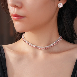 Close-up of sparkling pink rhinestone square necklace and flower stud earrings set on model