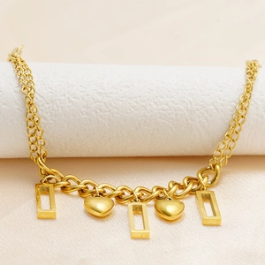 Double-layered 18K gold heart and rectangle pendant bracelet on a white stand