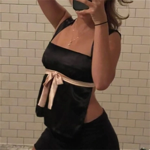 Sextes schwarzes Satin-Top mit rosa Schleifendetail vorne im Spiegel-Selfie gezeigt