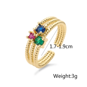 Detail of gold plated ring with red, blue, and green zircon stones and beaded texture
