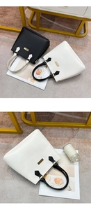 Detail of stylish PU leather tote bags in black and white with gold hardware