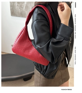 Close-up of red woven leather tote bag texture and detail on a model in a black leather coat