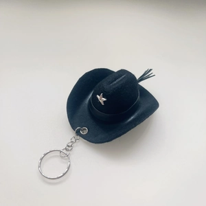 Detail of 8cm mini black felt cowboy hat keychain with silver star and feather charm