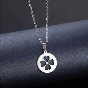 Macro shot of polished stainless steel round clover pendant with heart cutouts