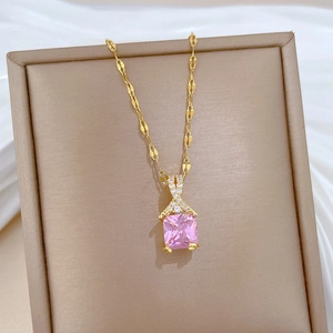 Detail of pink square stone pendant on golden chain displayed on a jewelry stand