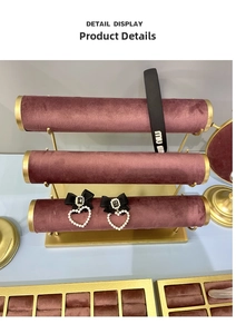 Detailed display of pearl heart earrings and branded headband on purple velvet display rack
