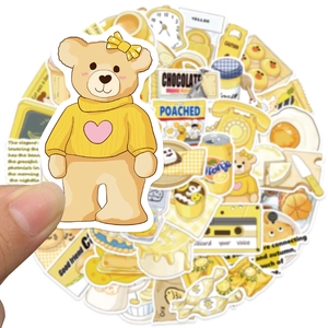 Nahaufnahme gelber Teddybär-Aufkleber und Lebensmittel-Illustrationen für Notizbücher
