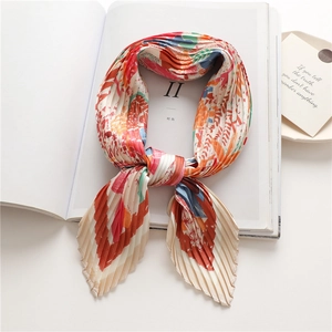 Foulard a pieghe con stampe astratte colorate arancioni e blu su una rivista bianca