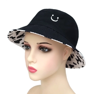Reversible bucket hat with smiley embroidery and cow print lining for sun protection