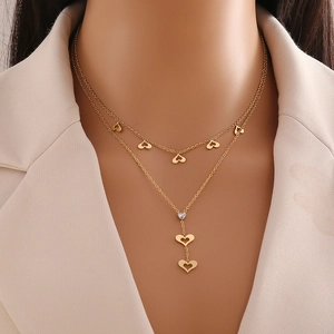 Detail of a layered gold heart necklace featuring a double-strand butterfly chain design