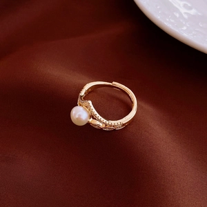 Macro shot of gold plated oval ring with pearl inlay and micro-pave cubic zirconia