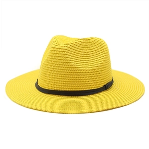 Close-up of yellow straw Panama hat with fine weave texture and black decorative ribbon