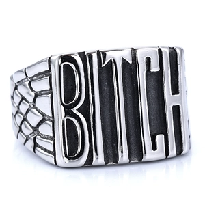 Macro detail of punk silver ring featuring BITCH engraving and snake scale textures