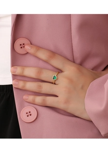 Detailed view of heart-shaped green zircon ring with gold plating on model finger