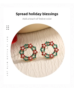 Close-up of gold Christmas wreath earrings with red green crystals and white pearls