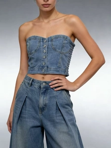 Détail du haut tube en jean bleu à boutons métalliques et jean taille haute