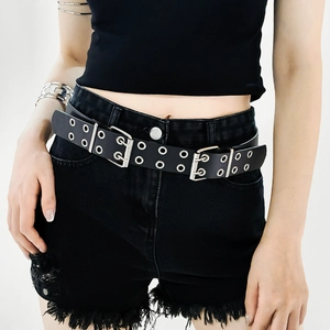 Close-up of black studded punk belt with double metal buckles and multi-row eyelets on model