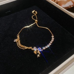 Macro shot of 18k gold plated bracelet with star charms and adjustable bolo clasp